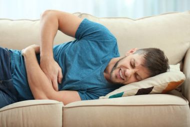 young man suffering from stomach ache clipart