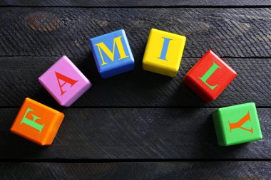 Word aile ahşap arka plan üzerinde renkli küpler