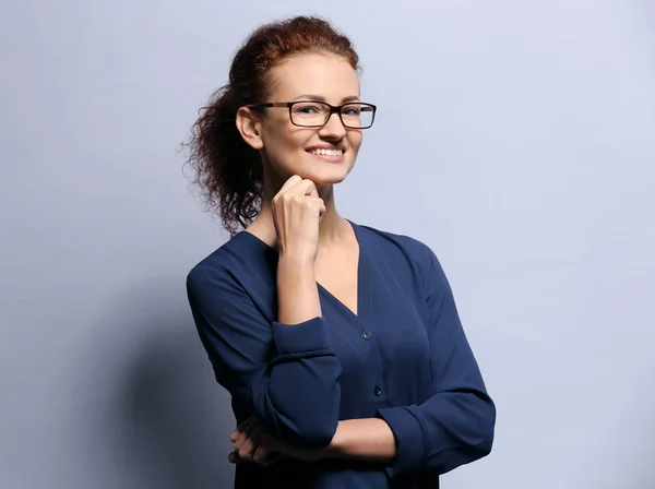 Mujer joven con gafas sobre fondo gris — Foto de Stock