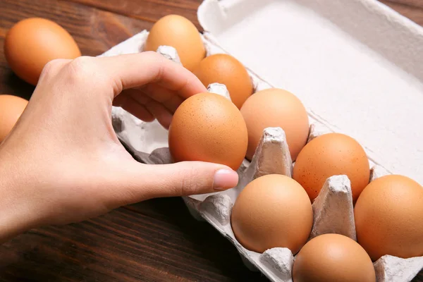Tar rått ägg från paketet — Stockfoto