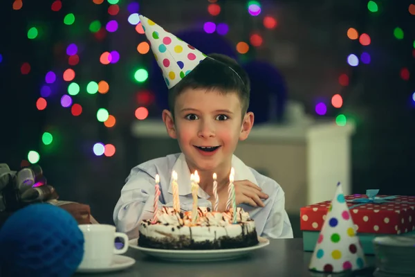 Surprised birthday boy with cake at party