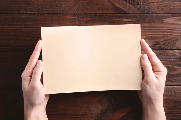 Руки держат пустой лист бумаги — стоковое фото