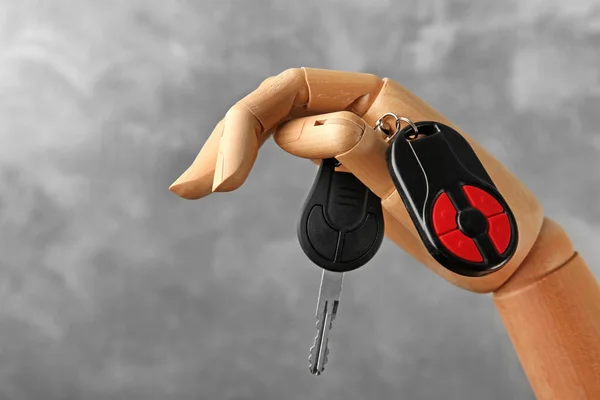 Wooden hand holding car keys — Stock Photo, Image