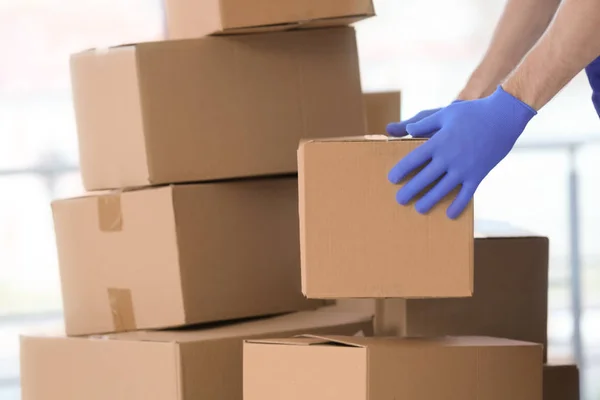 Чоловік-доставка рухає коробки в приміщенні — стокове фото