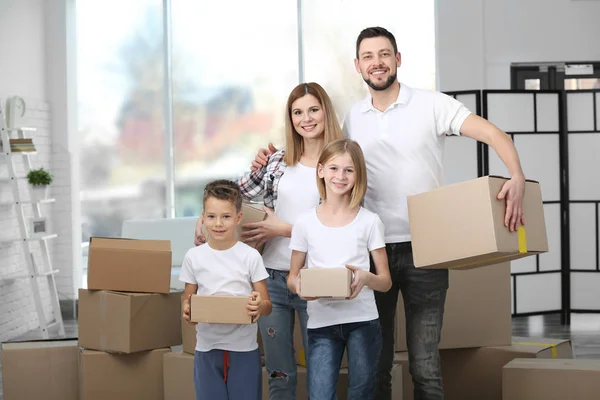 Glückliche Familie mit Kartons im neuen Haus — Stockfoto