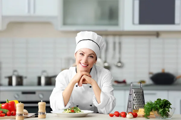 Jonge vrouwelijke chef-kok in de keuken — Stockfoto