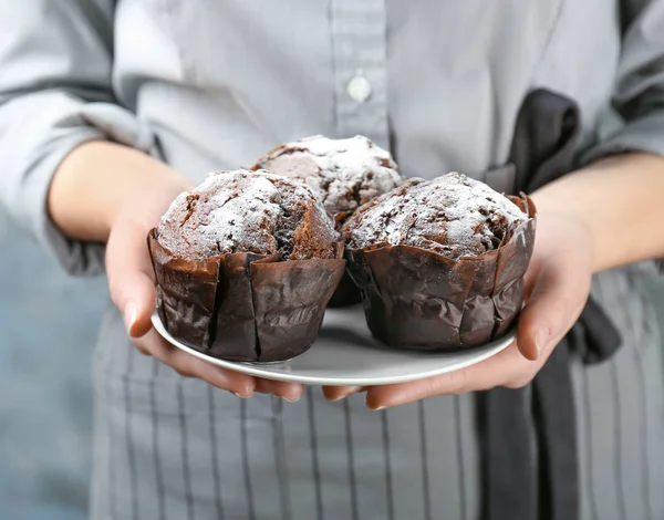Žena držící desku s čokoládové muffiny — Stock fotografie