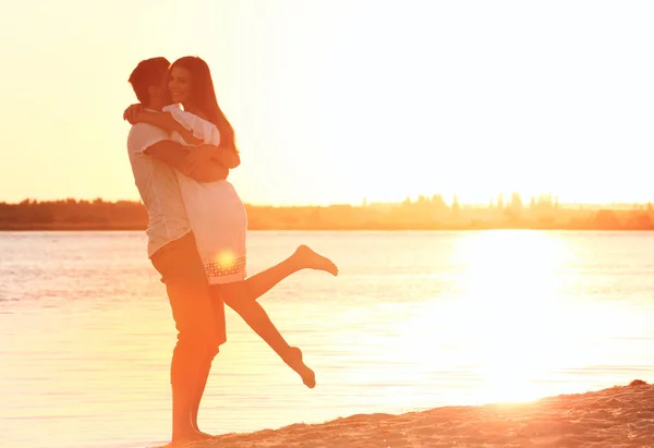 Молодая пара влюблена на летнем пляже заката — стоковое фото
