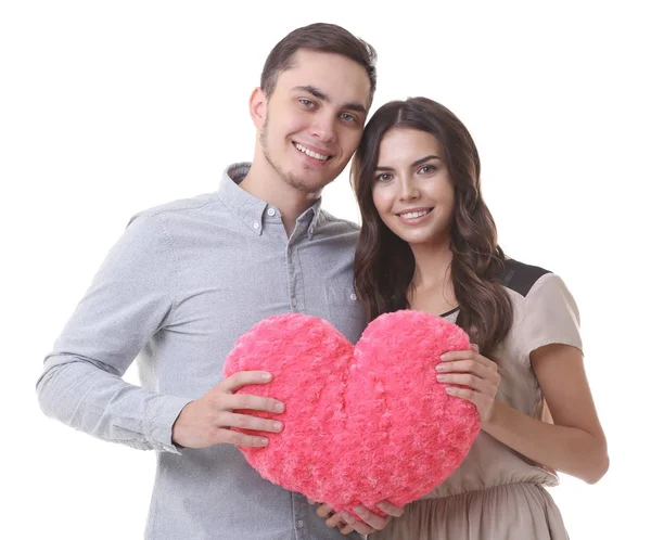 Bela jovem casal com travesseiro em forma de coração no fundo branco — Fotografia de Stock