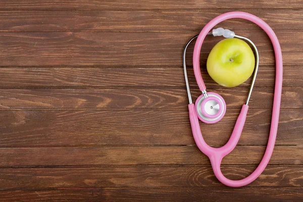 Pink stethoscope with apple — Stock Photo, Image
