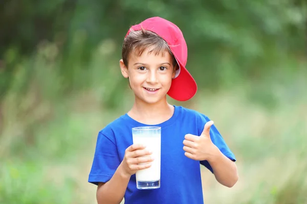 Kid hålla glas mjölk — Stockfoto