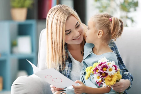 Ung kvinna och dotter sitter på soffa — Stockfoto