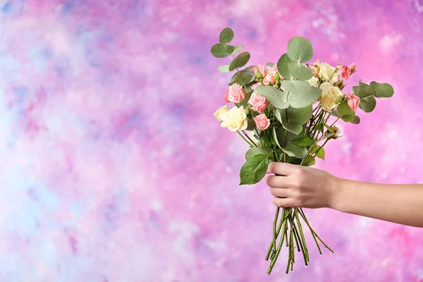 Weibliche Hand mit Rosenstrauß — Stockfoto