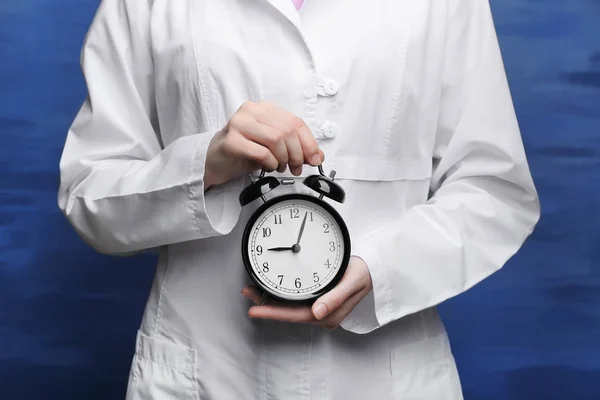 Doctor holding alarm clock — Stock Photo, Image