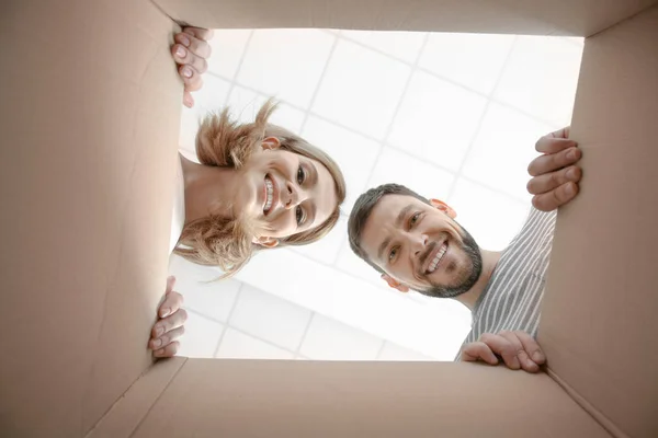 Young family looking through box — Stock Photo, Image