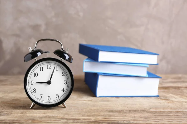 Reloj despertador y pila de libros —  Fotos de Stock