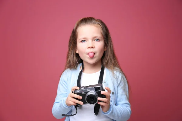 Liten flicka med vintage kamera på färgbakgrund — Stockfoto