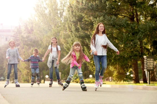 Cheerful children on roller skates in park — Stock Photo, Image