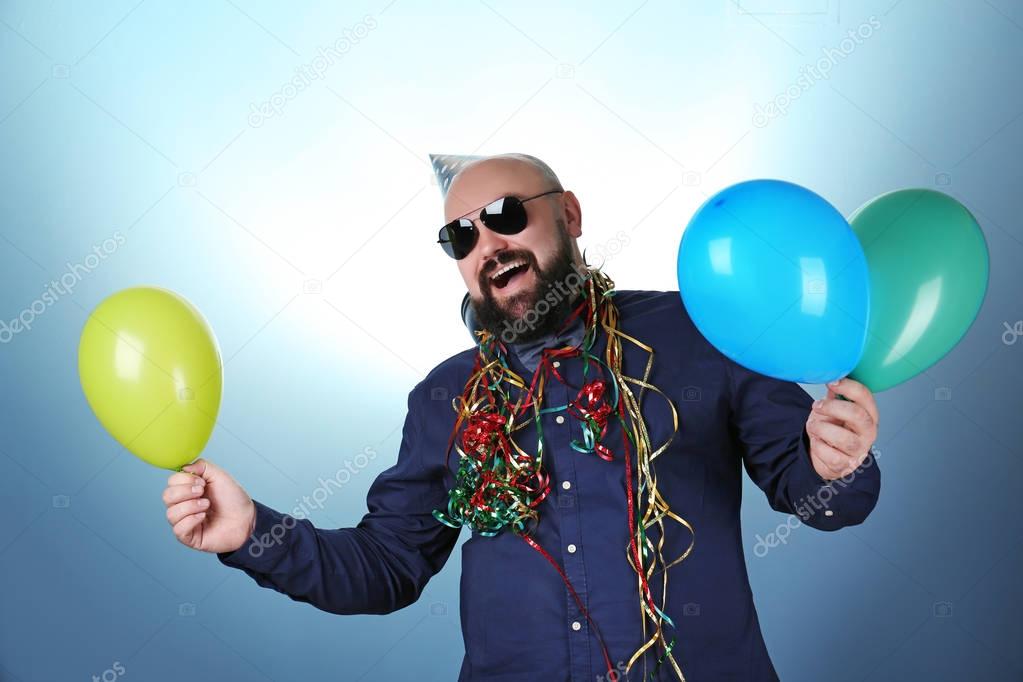 Funny man with birthday hat and balloons 