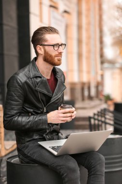 Dizüstü bilgisayarda çalışan genç adam. 