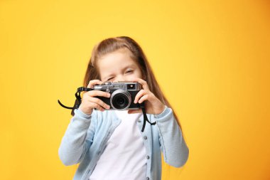 Küçük kız ile renk arka plan üzerinde vintage fotoğraf makinesi