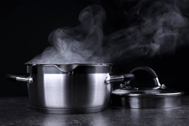 Koyu arka plan üzerinde buhar ile pan