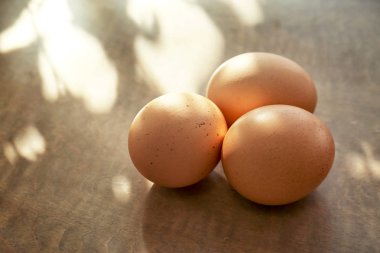 Ahşap masada çiğ yumurta.