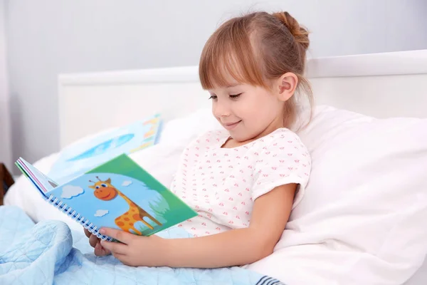 Pieni tyttö lukeminen kirja — kuvapankkivalokuva