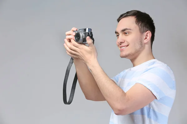 Hübsche junge Touristin fotografiert auf grauem Hintergrund — Stockfoto
