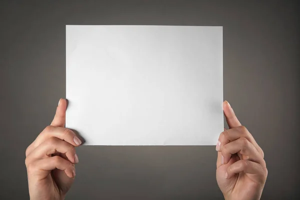 Hands holding empty paper sheet — Stock Photo, Image
