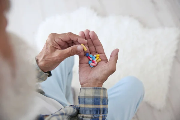 Hombre mayor tomando pastillas — Foto de Stock