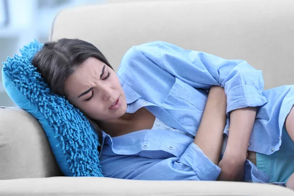 Femeie tânără care suferă de dureri abdominale — Fotografie, imagine de stoc