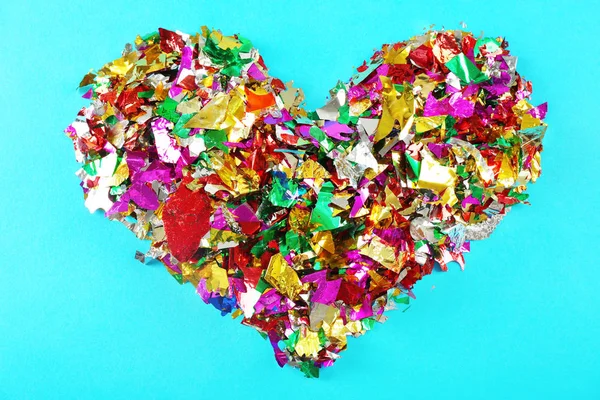 Конфетти в форме сердца на цветном фоне — стоковое фото