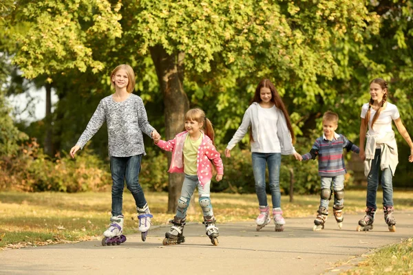 Crianças alegres em patins no parque — Fotografia de Stock
