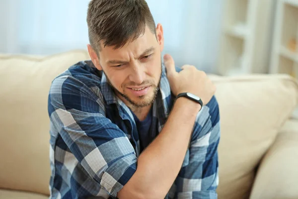 Young man suffering from pain in shoulder — Stock Photo, Image