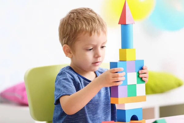 Schattige kleine jongen spelen met kleurrijke blokken thuis — Stockfoto