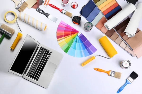 Laptop com amostras de cor e ferramentas de pintura — Fotografia de Stock