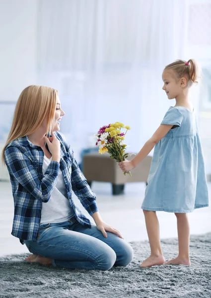 Flicka hälsning mor med blommor — Stockfoto