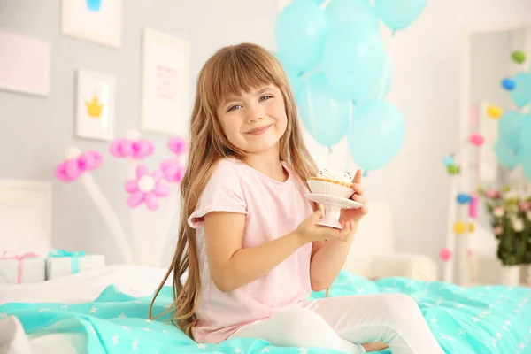 Χαριτωμένο κορίτσι με κέικ κάθεται στο κρεβάτι — Φωτογραφία Αρχείου