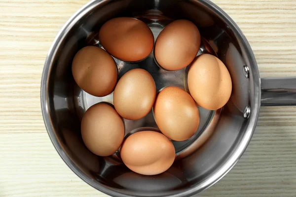 Raw eggs in saucepan — Stock Photo, Image