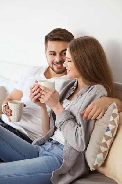 Pasangan muda duduk di sofa — Stok Foto