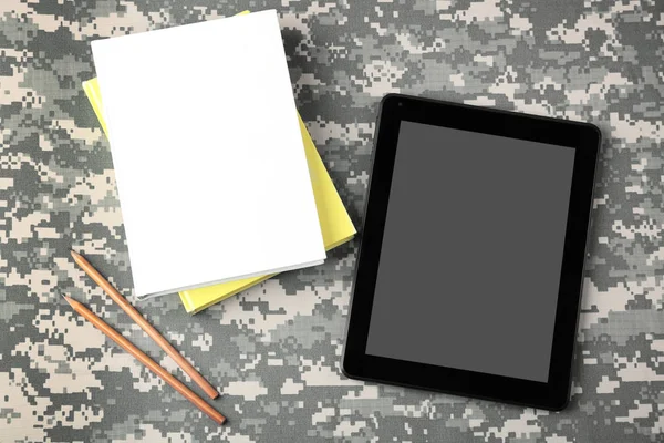 Tablett och copybooks på kamouflage — Stockfoto