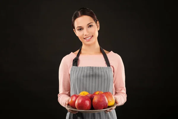 Jeune femme tenant la plaque avec des pommes — Photo