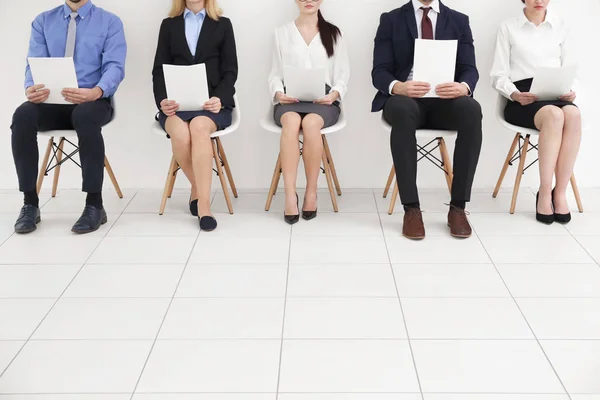 Gruppe von Menschen, die Papiere halten und auf ein Vorstellungsgespräch warten — Stockfoto