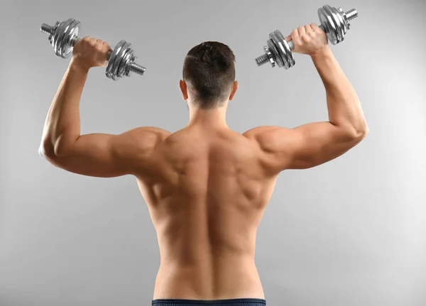 Sporty man doing exercises with dumbbells — Stock Photo, Image