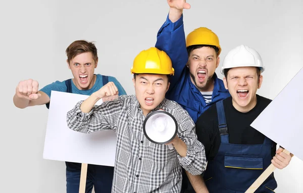 Groep van jonge mannen op lichte achtergrond protesteren — Stockfoto