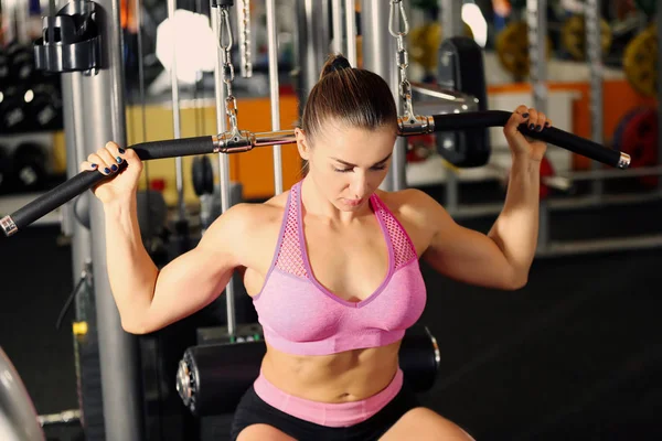 Junge Frau trainiert in modernem Fitnessstudio — Stockfoto