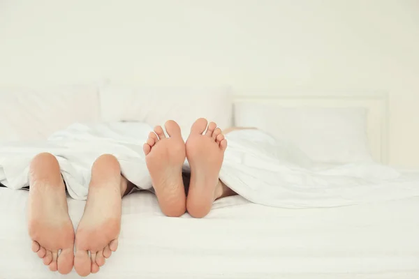 Parejas pies en la cama — Foto de Stock