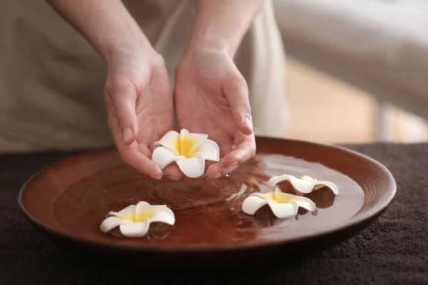 Mani femminili con ciotola e fiori — Foto Stock