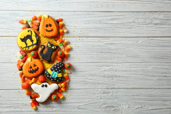 Halloween cookies and jelly sweets on wooden background — Stock Photo, Image